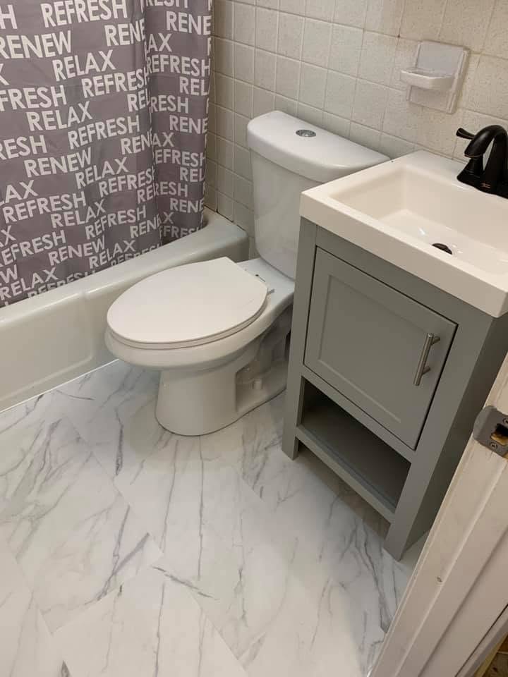 Finished bathroom with new marble-look floor and vanity