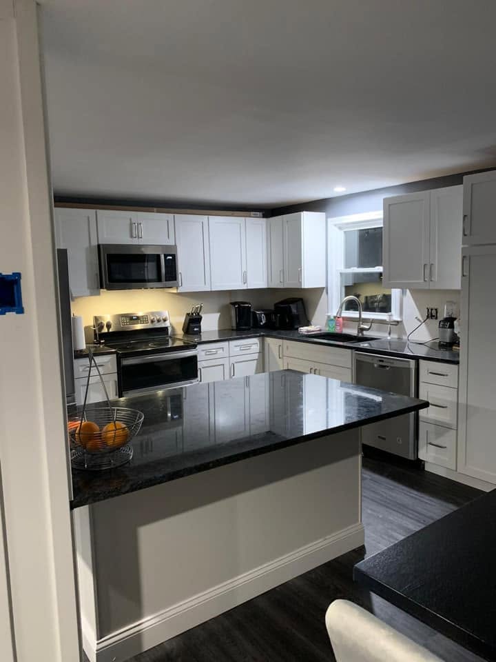 Kitchen remodeled by KLB Home Improvement — white shaker cabinets and granite island